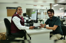 Servidora pública brinda atención directa a un ciudadano durante la entrega de un trámite, como parte de los servicios fiscales oficiales en el Edoméx.