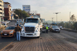 Al derrapar, el conductor impactó contra un tráiler y quedó tendido bajo la pesada unidad, que terminó por arrollarlo.