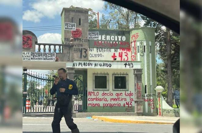 Estudiantes encapuchados pintaron consignas exigiendo justicia por el caso Ayotzinapa.