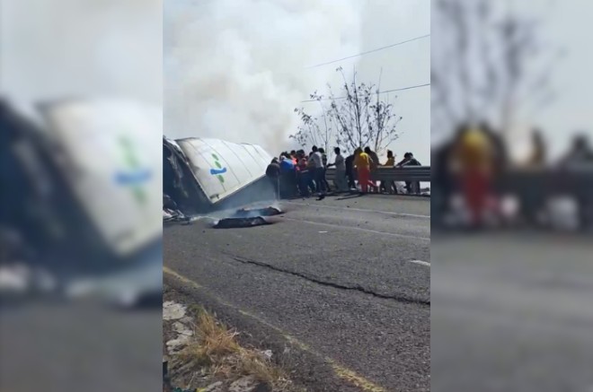 Mientras el tráiler ardía en llamas tras volcarse en la carretera Toluca-Palmillas, decenas de personas aprovecharon para cometer actos de rapiña.
