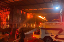Bomberos trabajan para contener el incendio en la fábrica de telas