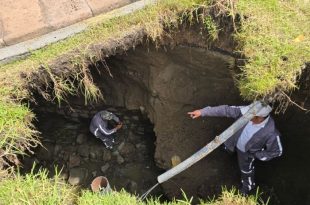 Personal del Organismo Agua y Saneamiento de Toluca realiza trabajos para reparar el socavón registrado.
