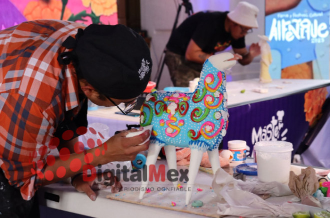 Maestro alfeñiquero da forma a una figura tradicional de azúcar