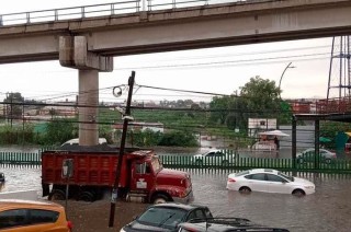 En el sitio se pudo ver vehículos pesados y a motociclistas intentado pasar por la avenida inundada