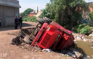 Cae camión con costales de maíz a canal de aguas negras