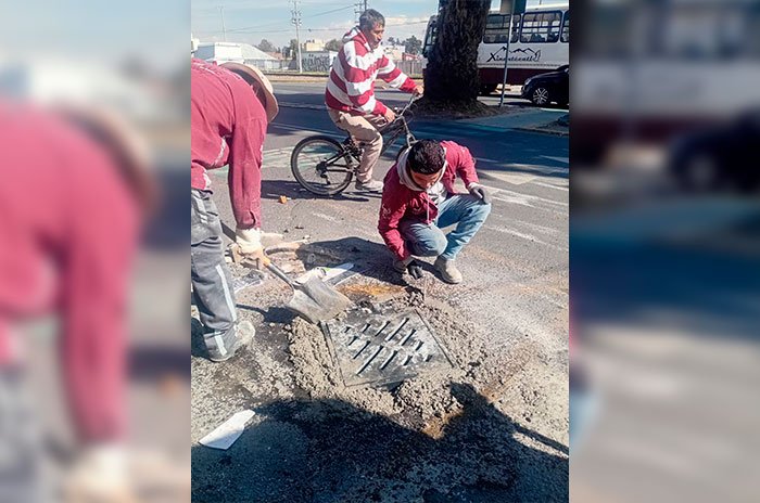 Personal del Organismo Agua y Saneamiento de Toluca realiza trabajos de limpieza y mantenimiento de coladeras para prevenir encharcamientos durante las lluvias.